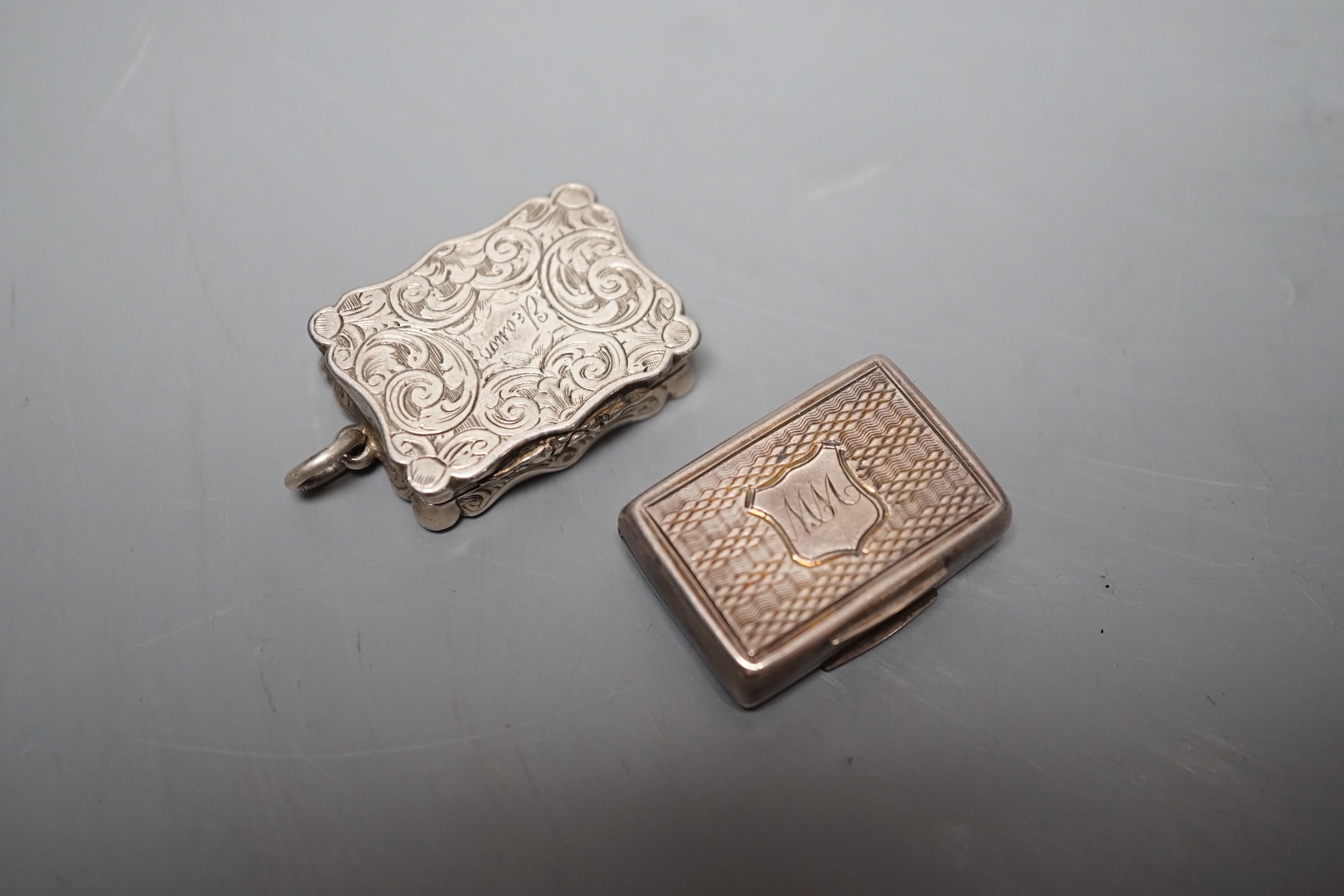 A Victorian engraved silver shaped rectangular vinaigrette, Alfred Taylor, Birmingham, 30mm, 1857 and one other silver vinaigrette by Francis Clark, 30mm, with engraved monogram.